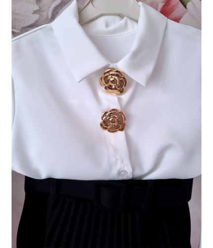 Stylowy zestaw galowy dla dziewczynki składający się z białej koszuli ze złotymi odpinanymi ozdobami oraz czarnej plisowanej spódniczki z paskiem. Idealny jako elegancki strój dla dziewczynki na szkolne uroczystości, akademie, święta i rodzinne okazje.