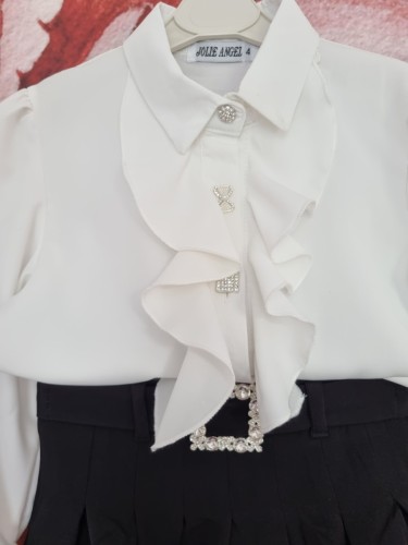 Elegancki zestaw galowy dla dziewczynki, białą koszula  z falbanką i ozdobnymi guzikami i spódniczka z ozdobnym paskiem