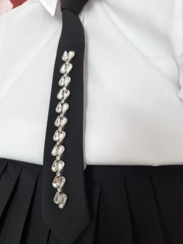 Elegancki biało czarny strój galowy, biała koszula z krawatem i czarna plisowana spódnica